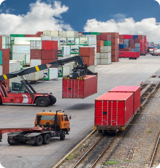 Forklift loading container onto train at port.